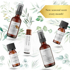 Five brown glass bottles from Wild Nurturer Aromatherapy are arranged on leaves, with a gold banner: “New seasonal scent every month!”—a perfect gift from the Aroma of the Month Club: Monthly Aromatherapy Subscription.