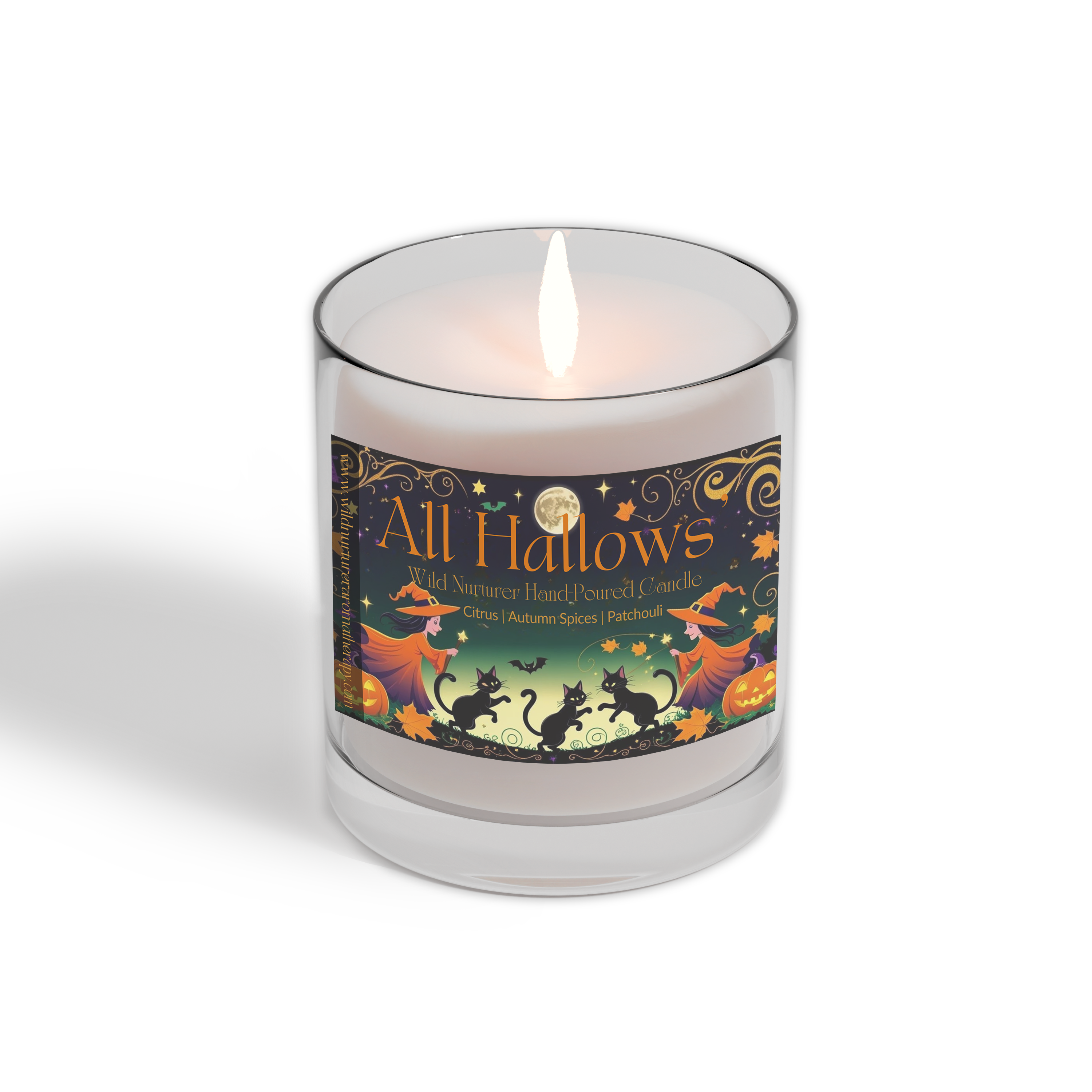A lit, hand-poured Wild Nurturer Aromatherapy candle from the Candle Club - Monthly Subscription Delivery, featuring a Halloween-inspired "All Hallows" design with witches, pumpkins, and autumn motifs.