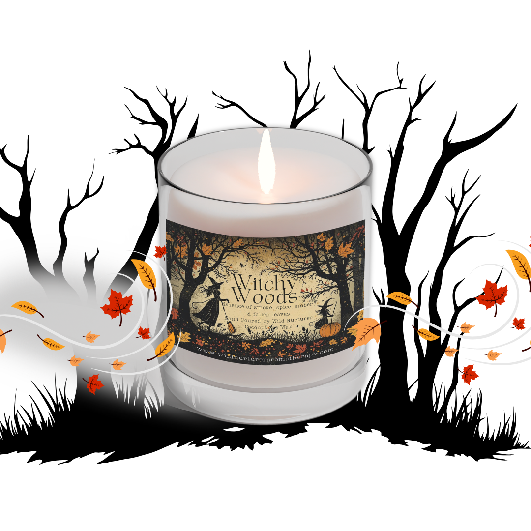 A lit, hand-poured Harvest Moon Soy Candle by Wild Nurturer Aromatherapy—blended with pear, apple, patchouli, and a hint of spice—rests before silhouetted trees, autumn leaves, and swirling wind on a white background, evoking the mysterious spirit of an enchanted forest.
