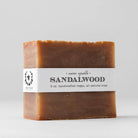 A rectangular bar of Nectar Republic's Sandalwood Bath Soap emits an earthy fragrance against a plain background. It is labeled as "5 oz. handcrafted vegan, all-natural soap" and offers anti-inflammatory properties for soothing care.