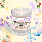 The Candle - Midsummer Night's Dream - Magical Fairy Candle from Heaven & Earth Aromatherapy glows amid butterflies and flowers, creating a whimsical ambiance—perfect for dreamy summer nights with its coconut soy wax blend.