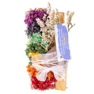 The SAGE W/ 7 CHAKRA FLOWERS, PALO SANTO, & GEMSTONE SMUDGE KITS: AMETHYST from Benjamin International features vibrant dried flowers and tied cedar sticks in a "smudging kit," enhanced by Sage and Palo Santo.