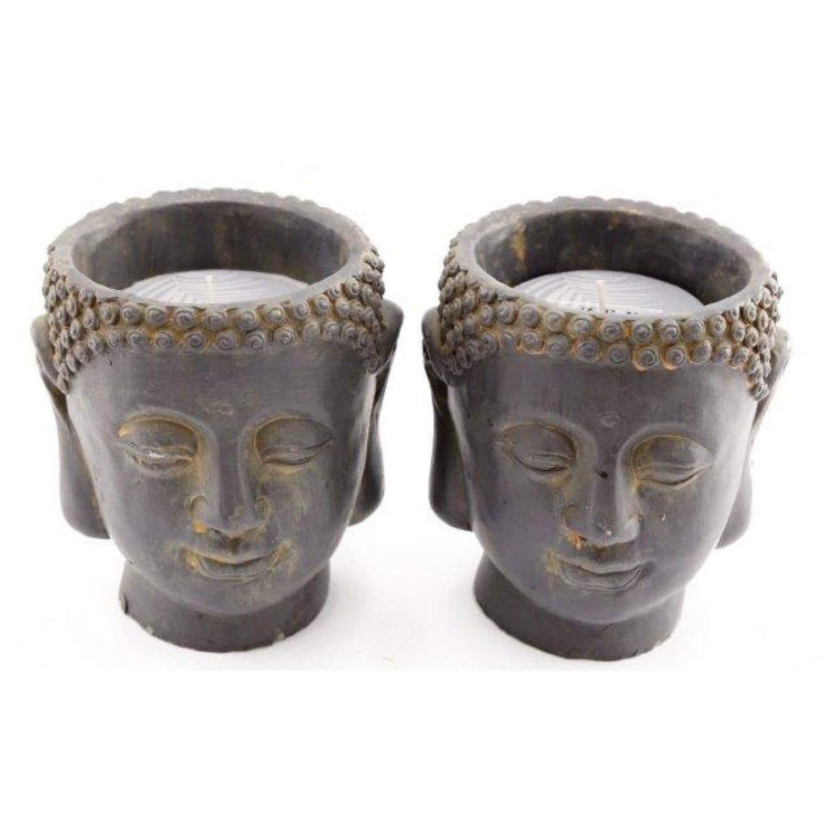 Two 16cm Cement Buddha Candles by Something Different Wholesale, depicting serene facial expressions with intricately detailed hair and closed eyes, feature a faux patina finish that adds an antique charm.