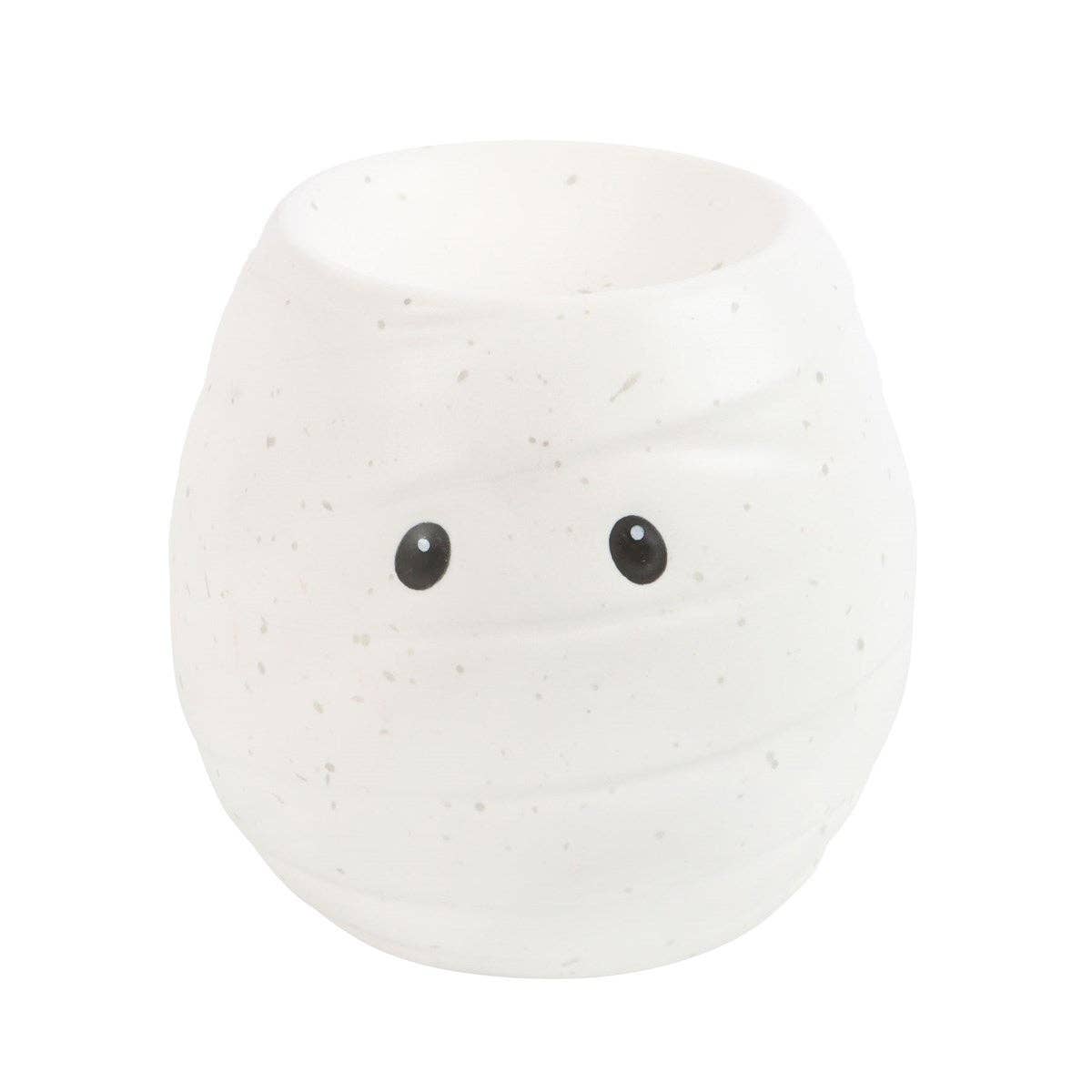 The Mummy Shaped Halloween Oil Burner from Something Different Wholesale is a small, white, round pot with a subtle speckled texture and two black eyes on the front, perfect for your Halloween decorations.