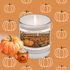 A lit Pomegranate Cider Soy Candle by Wild Nurturer Aromatherapy fills the air with notes of pomegranate, apple, and vanilla spice as it sits on an orange pumpkin-patterned background, beside a pumpkin and a pumpkin spice latte illustration.