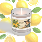 A glass "Kitchen Witch - Coconut Soy Wax Clean Burning Candle" by Heaven & Earth Aromatherapy sits among fresh lemons and green leaves, offering a refreshing, odor-neutralizing candle experience.