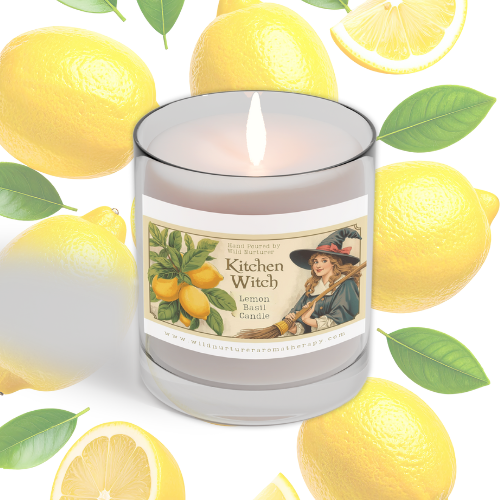 A glass "Kitchen Witch - Coconut Soy Wax Clean Burning Candle" by Heaven & Earth Aromatherapy sits among fresh lemons and green leaves, offering a refreshing, odor-neutralizing candle experience.