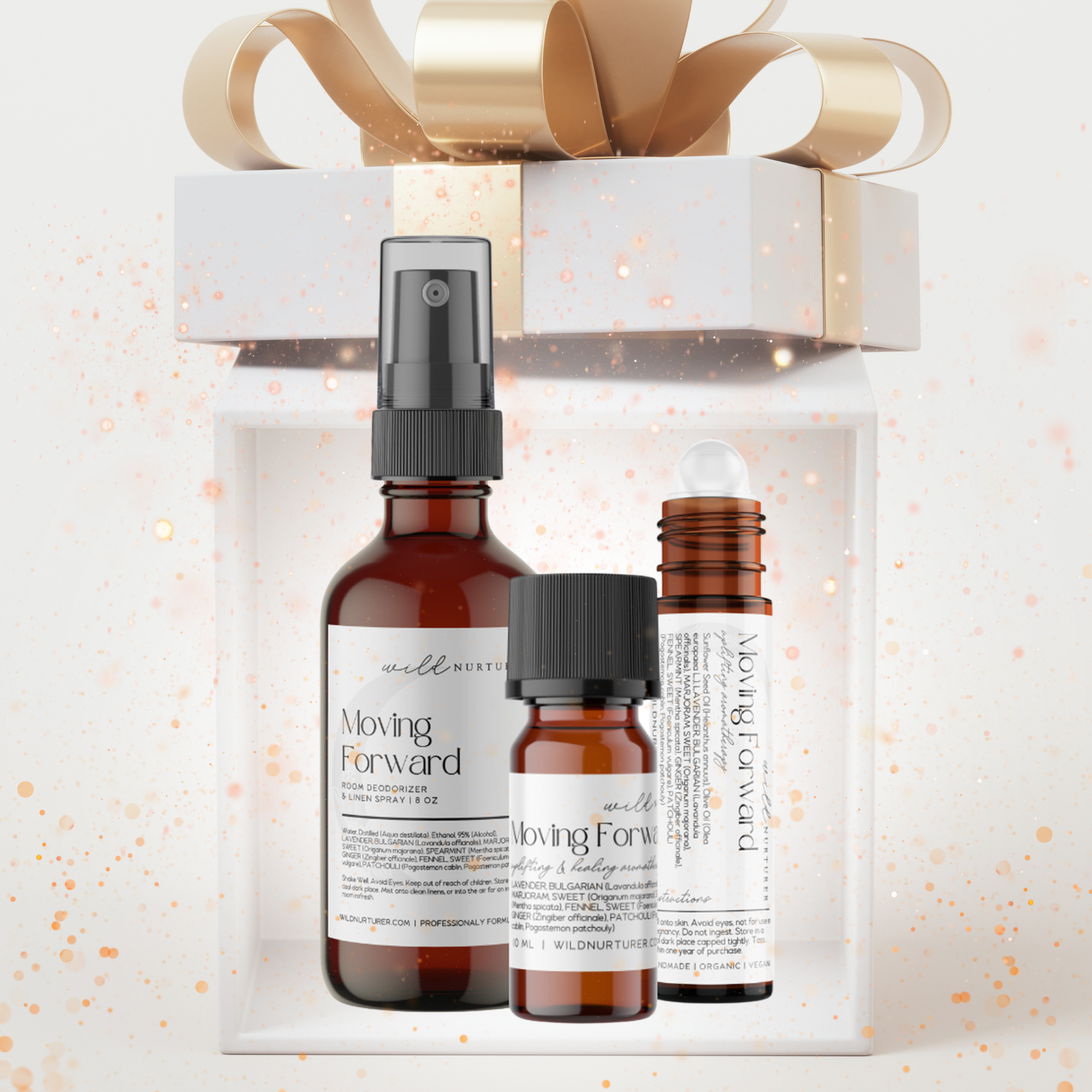 Three amber skincare products sit in front of a decorative gift box with a gold bow, surrounded by sparkles. Infused with essential oils, this set adds an indulgent touch to any Heaven & Earth Aromatherapy Monthly Subscription Box.