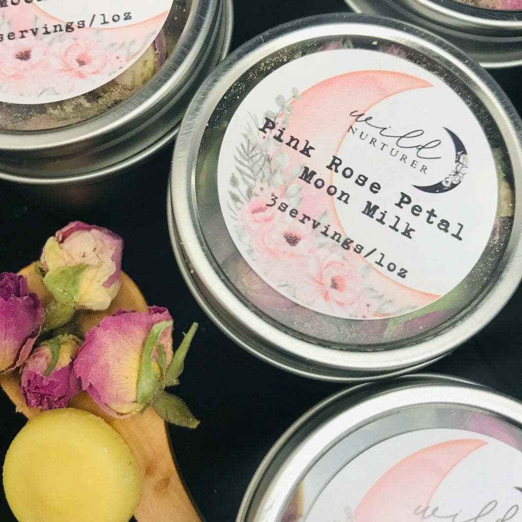 Tins of Moon Milk with a wooden spoon and flowers